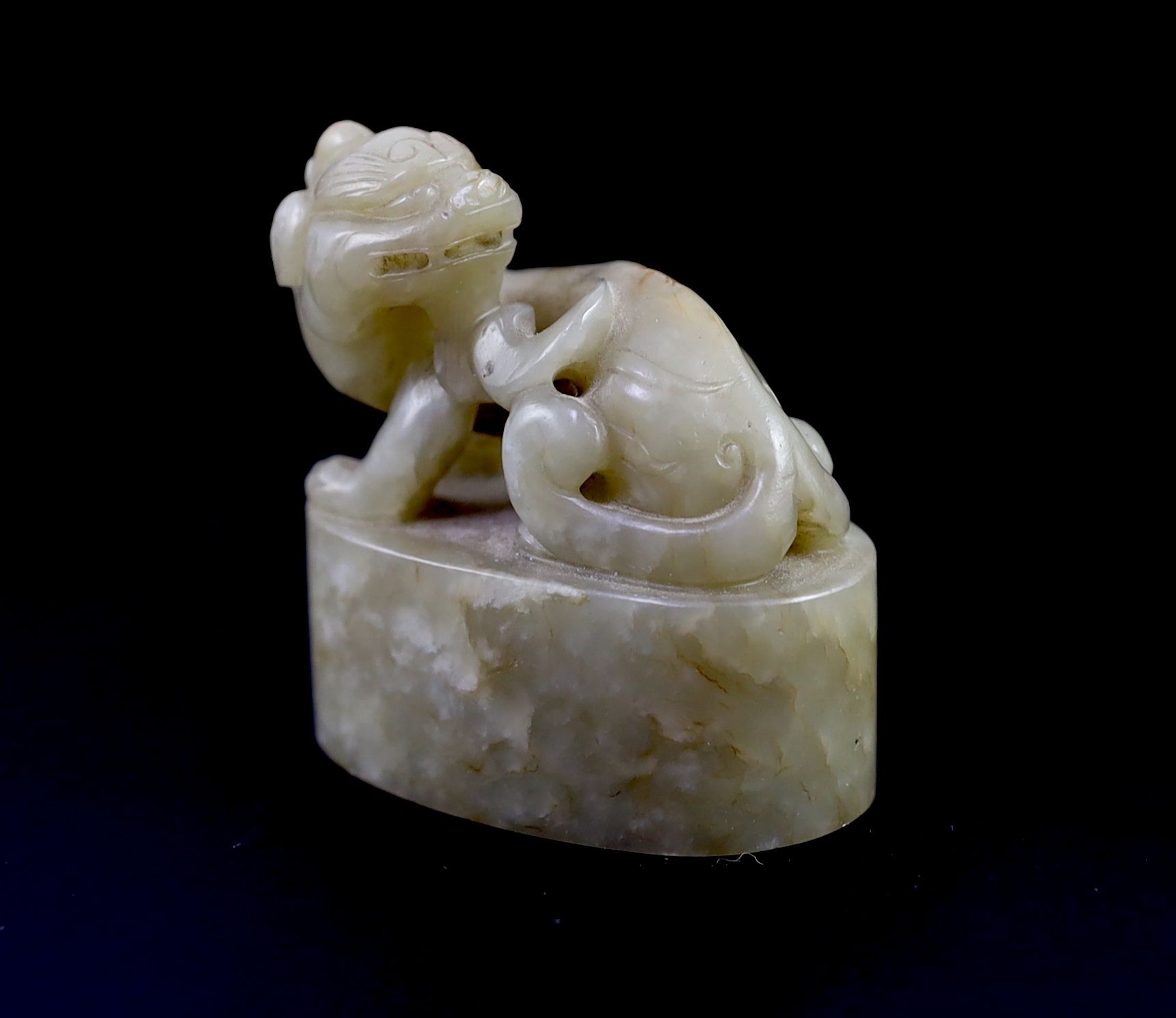 A Chinese celadon and white mottled jade ‘lion-dog’ seal, 18th/19th century, 6cm long